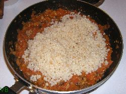 Amestecul de rosii, ceapa, ciuperci peste care se adauga couscous-ul